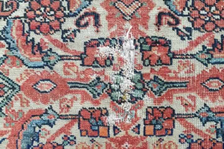 A worn antique rug about to be repaired and restored