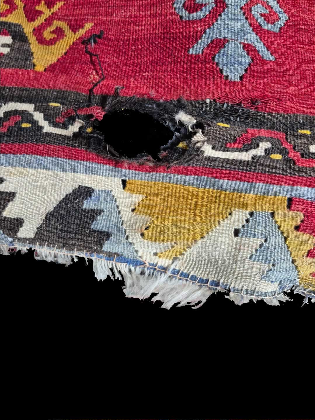 Kilim with a hole enar the edge + a damaged fringe